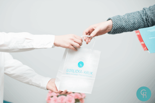 Kobiety podają sobie torebkę